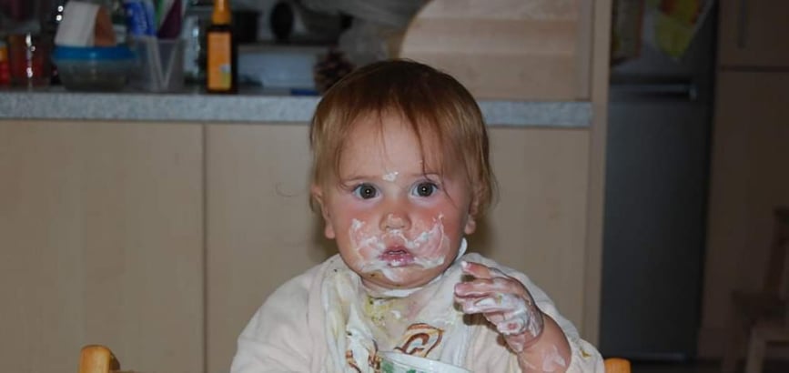 Beikost ist Begreifen Baby isst Joghurt mit den Händen Babyled Weaning