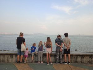 vegane Familie steht vor einer Mauer am Meer in Penang