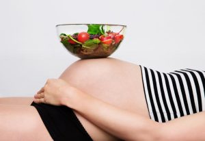 Schwangerschaftsbauch mit Salatschüssel